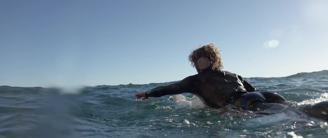A surfer swims in the ocean