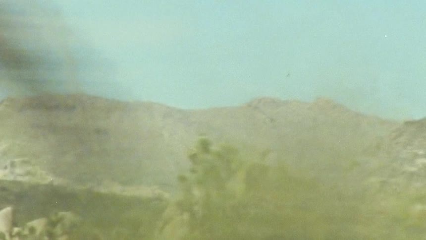 A landscape with bare trees and large rock formations