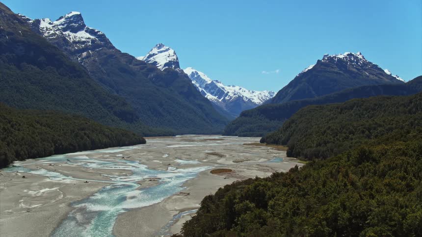 Huge New Zealand landscape with braided river and the tips of the mountains have snow