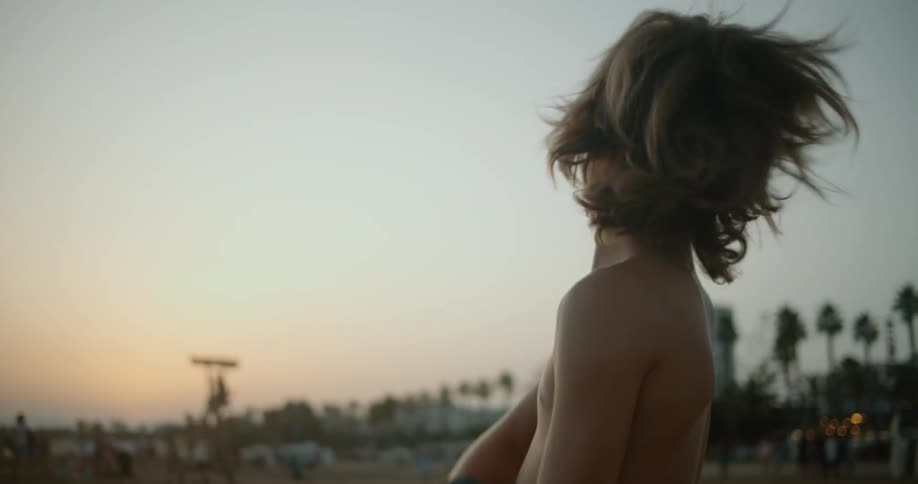 A young white child is on the beach about to go swimming