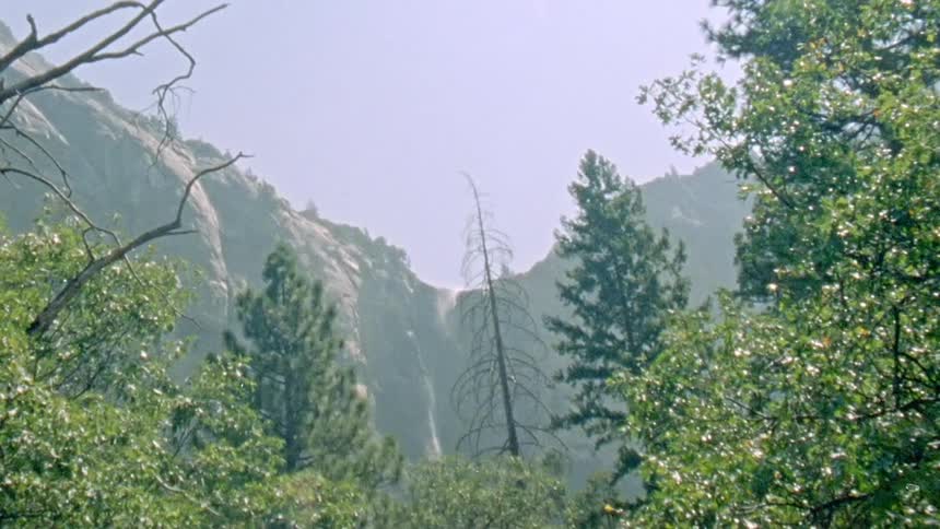 Waterfall carried away by the wind on a tall mountain caught on vintage film