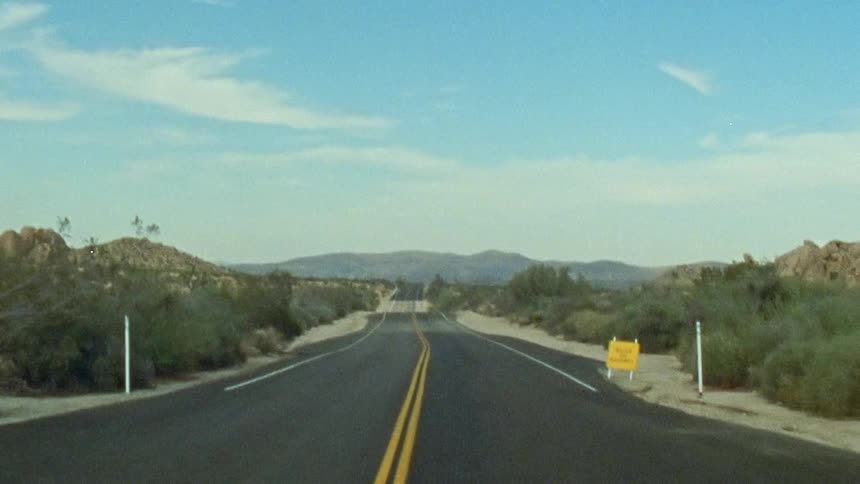 Road through the desert at morning caught on vintage film