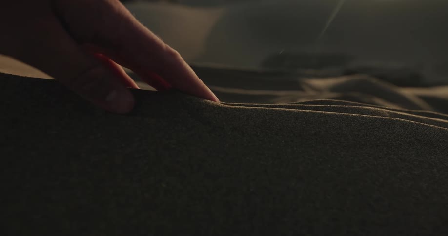 Someone is touching the sand on the beach in the day time