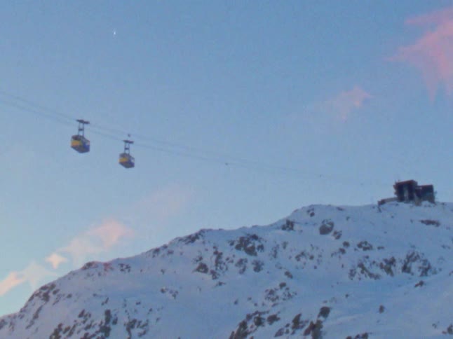 Gondolas traveling over a snowy mountain slope in winter