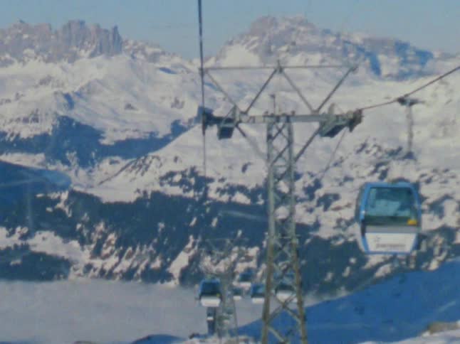 Gondolas traveling over snowy mountains in winter