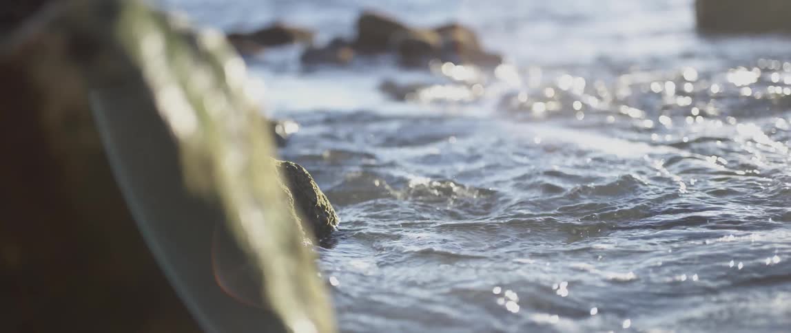 Waves swirl around the rocks in the water