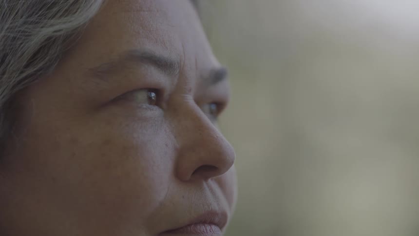 An older woman turns and looks to the side