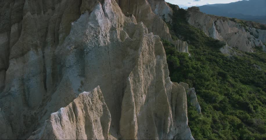 Aerial footage shows the jagged cliffs of a large mountain range