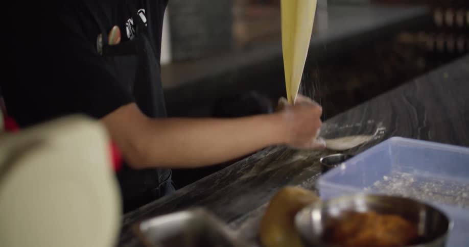A male restaurant worker preparing food in the kitchen