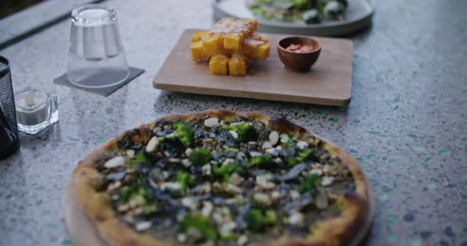 A server puts a pizza on a counter