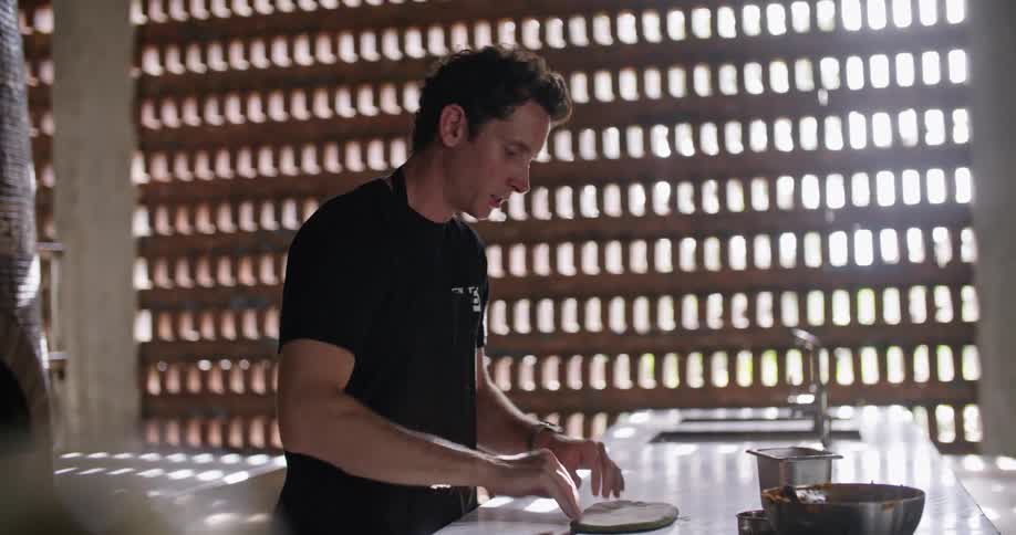 Restaurant worker prepares a pastry on the kitchen table at morning