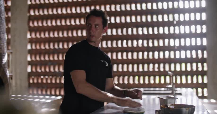 Man kneading dough over the table in the restaurant kitchen