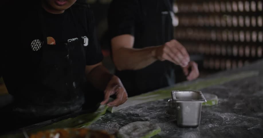 Two male restaurant employees preparing food in the kitchen