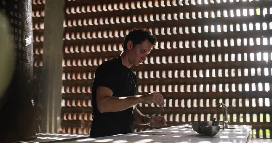 Man kneading dough over the table on a restaurant kitchen