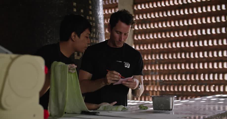 Man arrives with ticket to talk to cook working with pasta dough