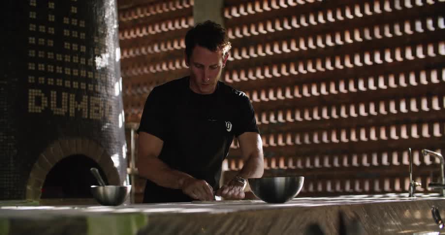 Man kneading dough over the table at a restaurant in the morning
