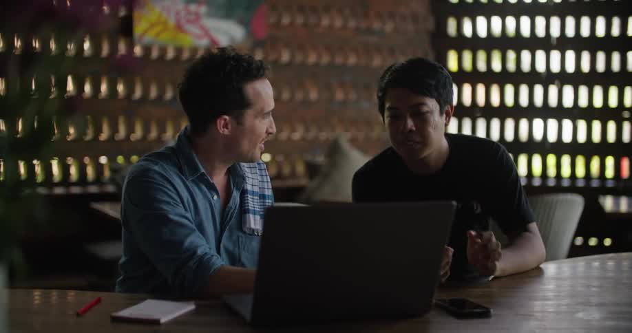 Restaurant owner and worker looking at a laptop over a table