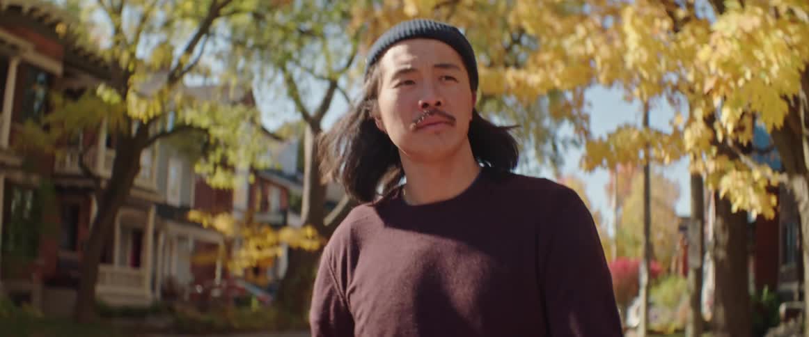 Man carries disassembled skateboards on the streets of a town in the morning