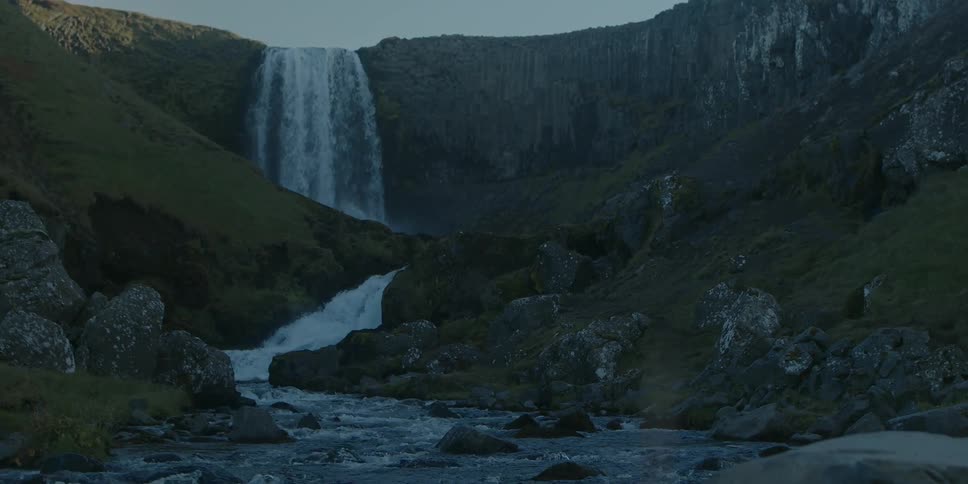 A large waterfall flowing over a cliff in nature
