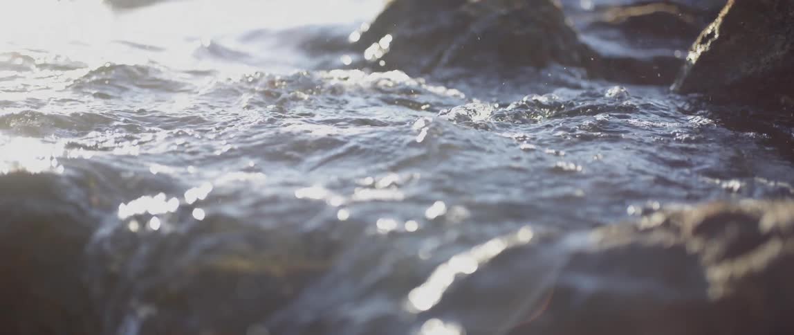 The tide rushes over some rocks during the day