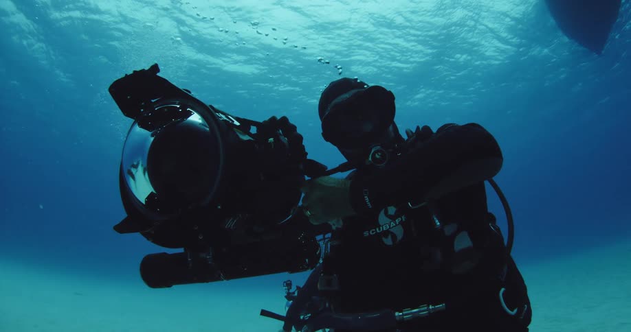 A man films with an underwater camera
