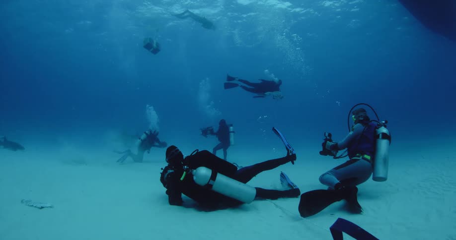 People underwater scuba diving near the bottom