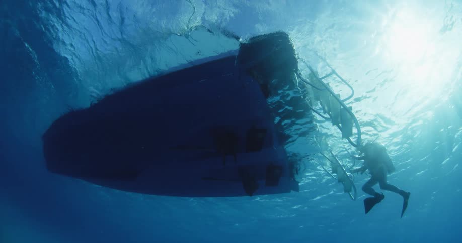 The bottom of a boat is shown floating on the ocean
