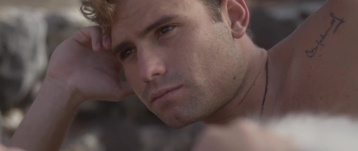 A man laying on his side looks off into the distance