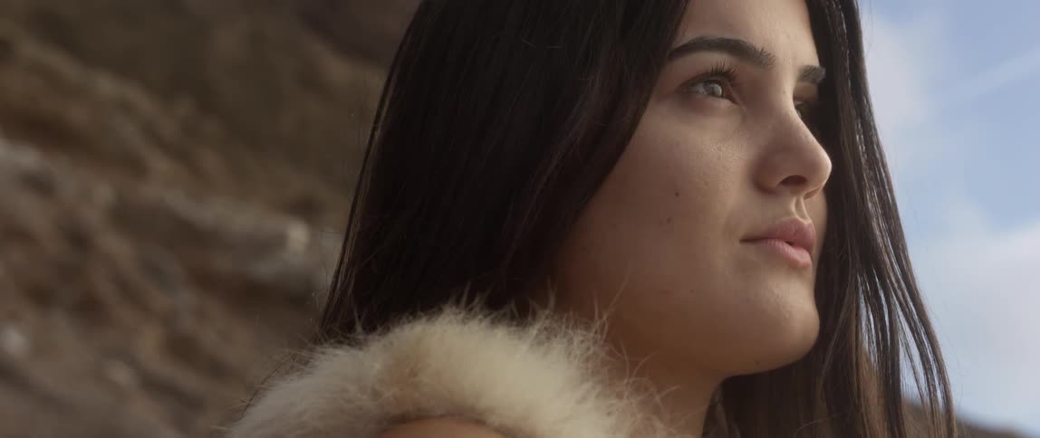 A dark haired woman looks off in the distance