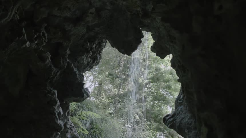Small waterfall as seen from inside a cave