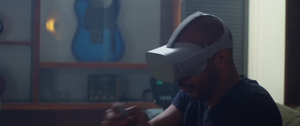 A man plays a virtual reality game on the couch