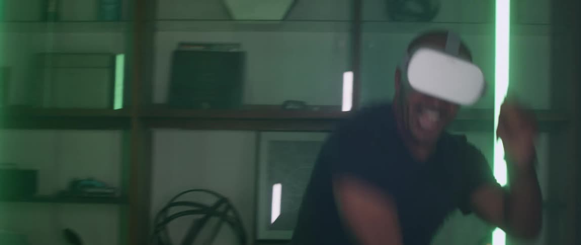 A man makes tennis motions while playing a game on a virtual reality headset