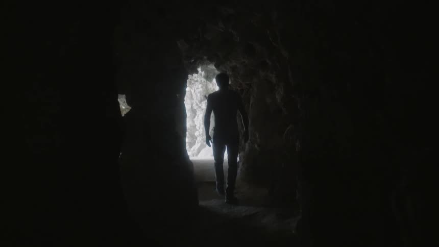 A man walks through a corridor in a cave