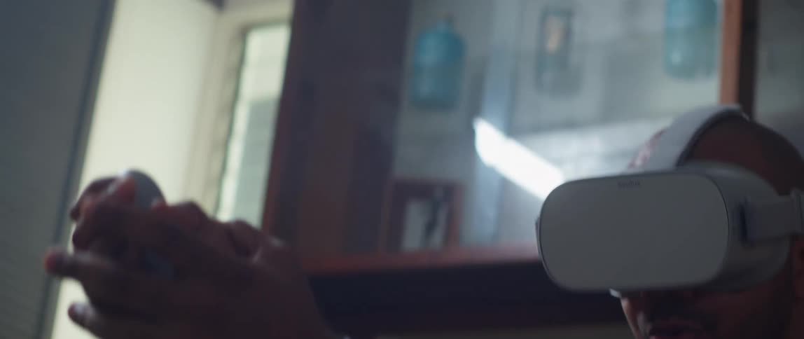 A man performs the motion of drawing a sword while playing a virtual reality game