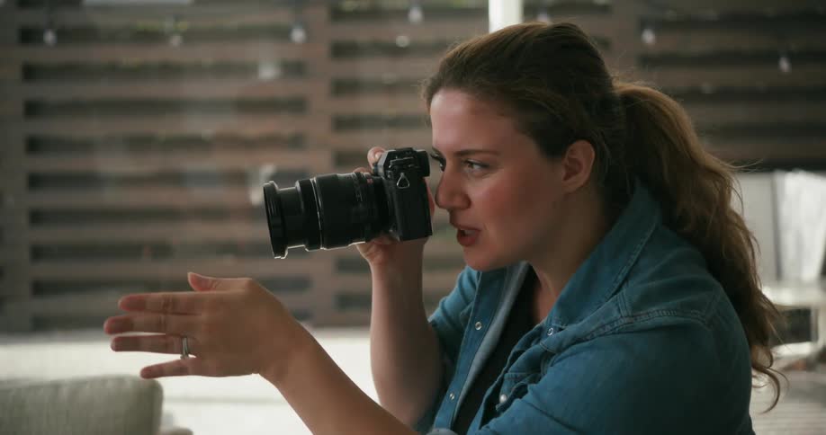 A photographer uses her hand to instruct a person to move over
