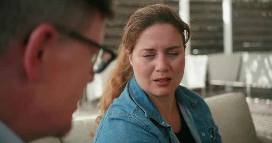 A man and woman sit outside and talk