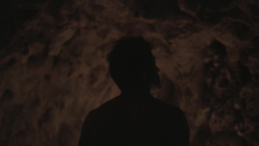 A man walks down a very narrow tunnel