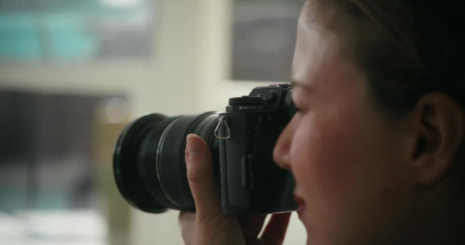 A woman takes photos on the back patio of a home