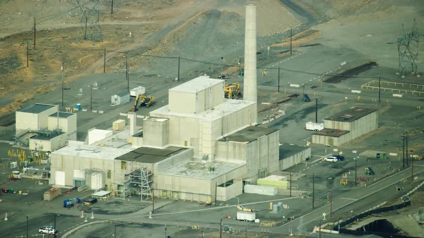 An aerial view of an industrial nuclear manufacturing building reveals that it has a tall smoke stack
