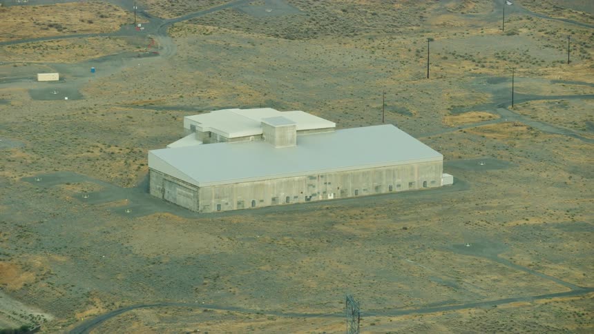 A nuclear building sits in a rural grassland