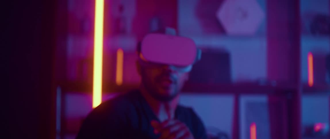 A man wearing a virtual reality headset swings his arms as he dodges objects in the game