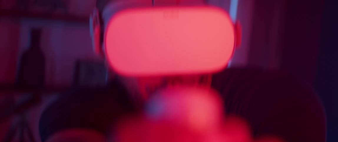 A man wearing a virtual reality headset excitedly aims his controller