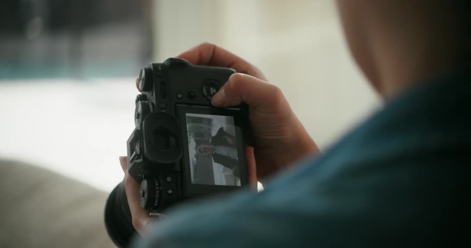 A photographer goes through images of a man on his digital camera