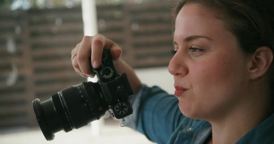 A person is holding a camera outdoors during the daytime