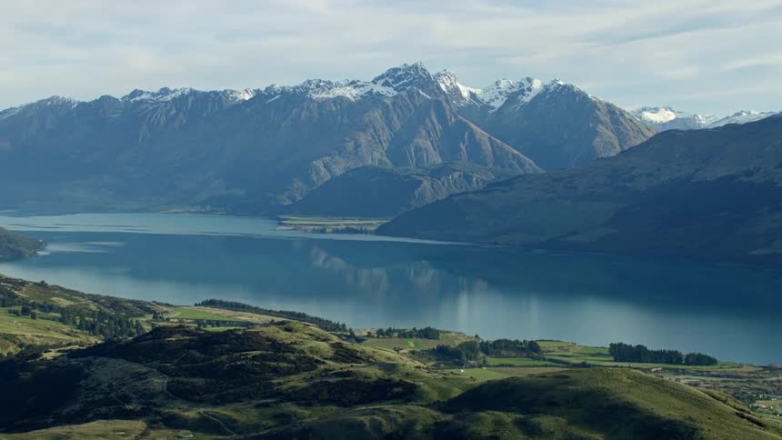 A reflective blue lake in front of a mountain range