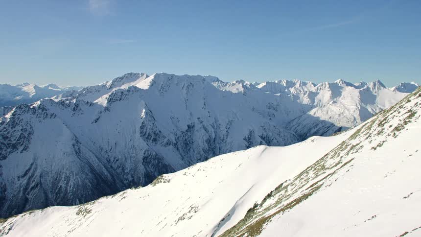 Aerial view of the snow covered slopes of a mountain range at daytime