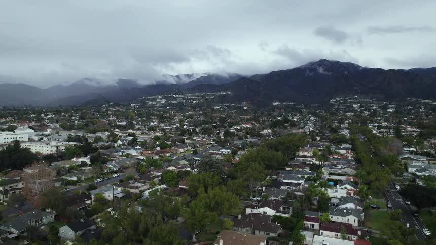Dozens of homes sit close together in a neighborhood near a mountain range