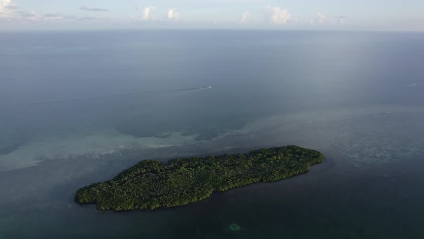 Aerial view of a small island in the middle of the blue ocean at daytime