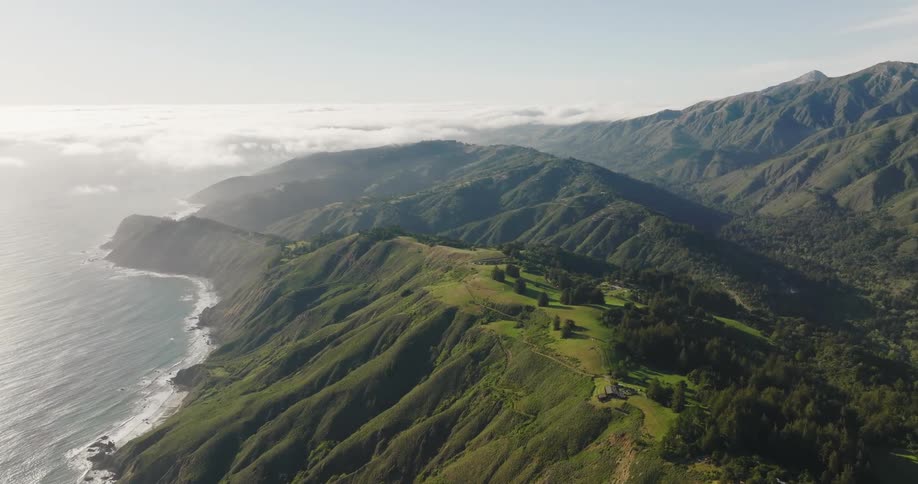 Low vegetation covered mountains on the coast during the day