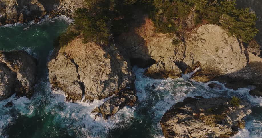 Aerial view of boulders and promontories on the coast at evening